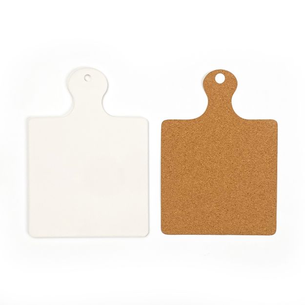 Two square serving boards with rounded handles, one white and one brown cork.