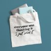 White canvas tote bag with the text “everyone was thinking it I just said it,” containing a laptop and a notebook.